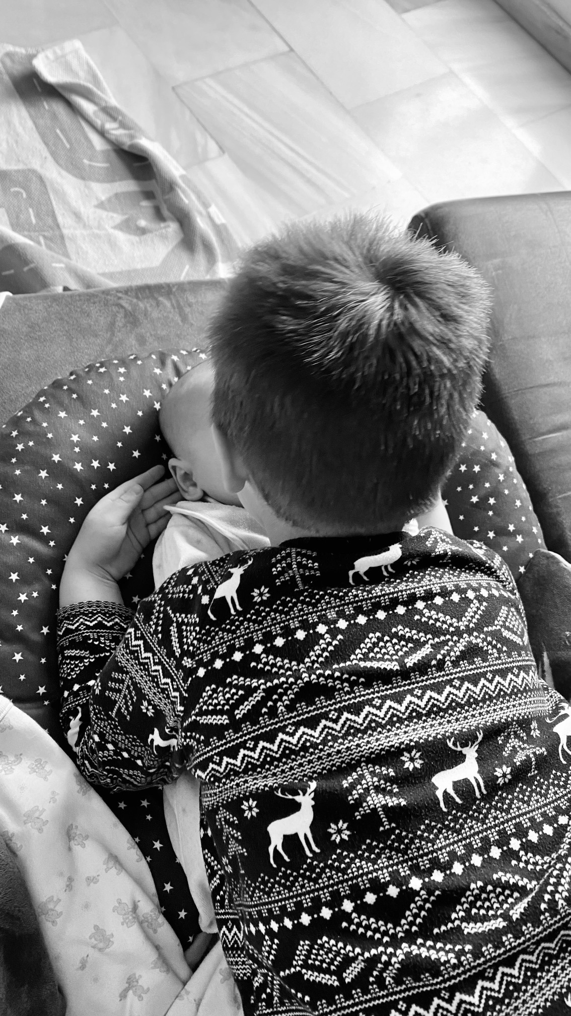 Çun niño de espaldas sujetando la cara de un bebé. Ninguno muestra su cara